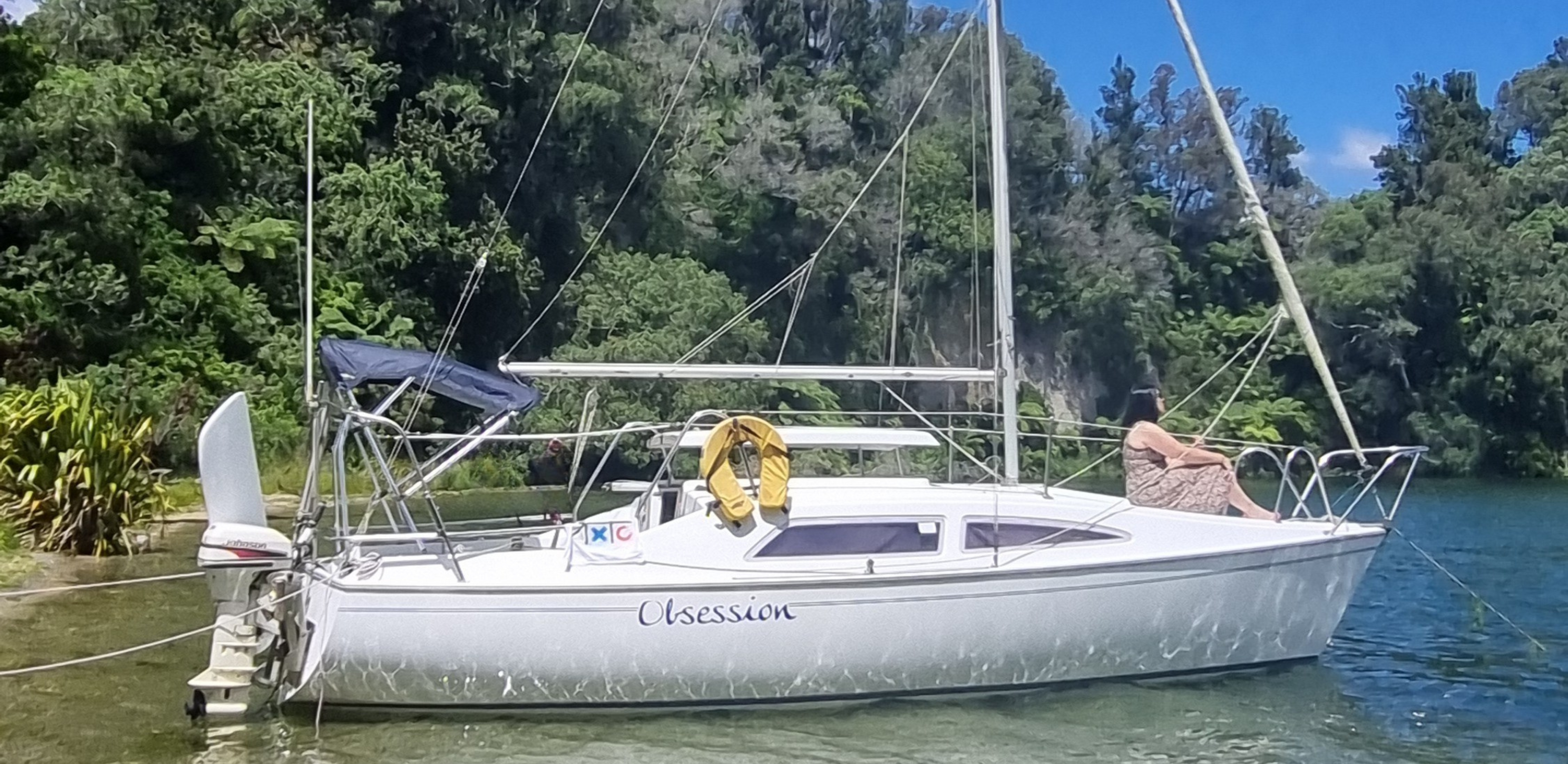 Woman sitting on the bow of a yacht on a lake in NZ