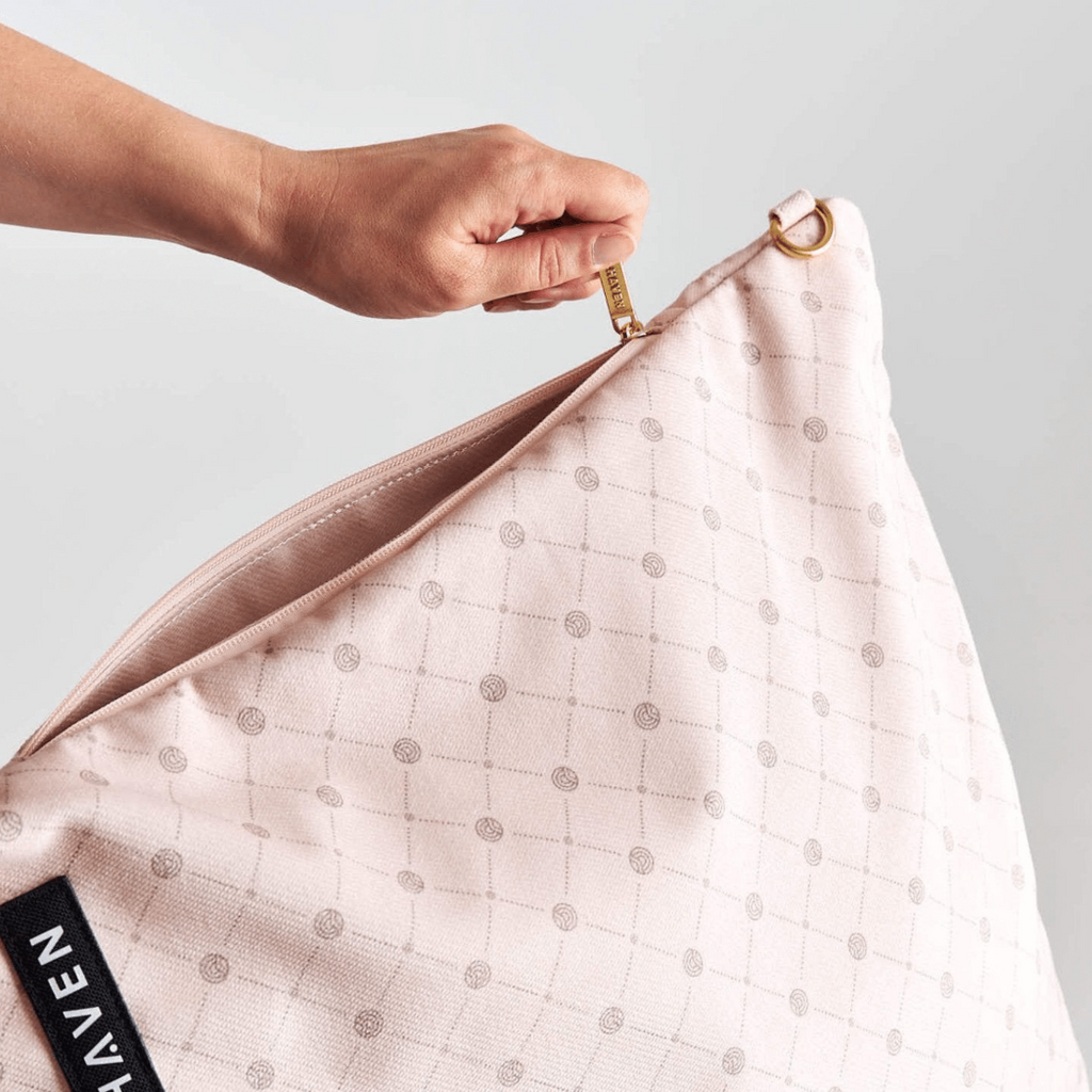 Solhaven Dream First™ Pillow Bag - Sole -a hand is showing the zip for the outer storage pocket